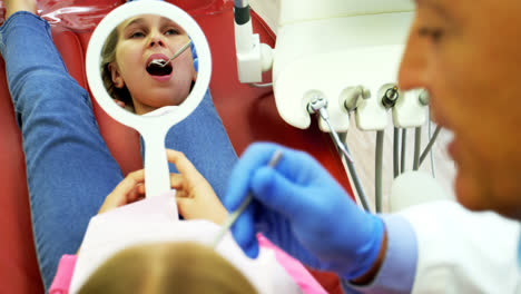 Dentist-examining-a-young-patient-with-a-tool