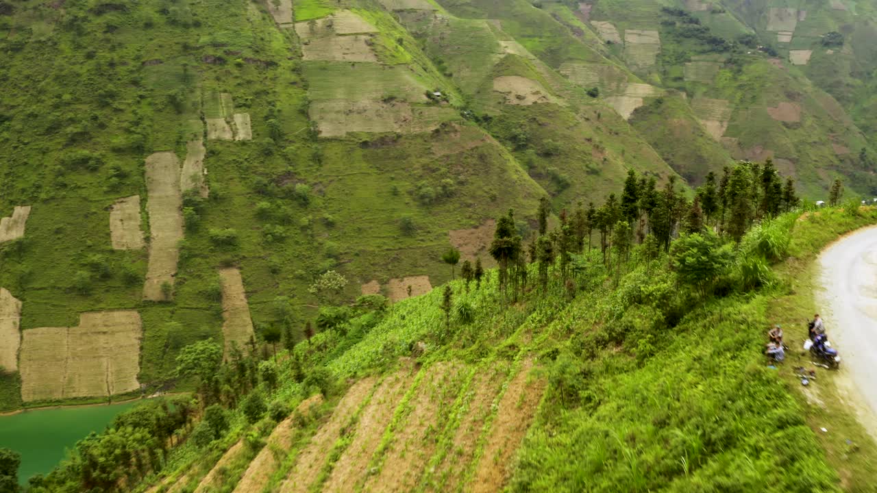 muévase lentamente hacia adelante a lo largo de un estrecho camino de montaña para revelar agua azul cristalina bloqueada por una represa en el norte de vietnam