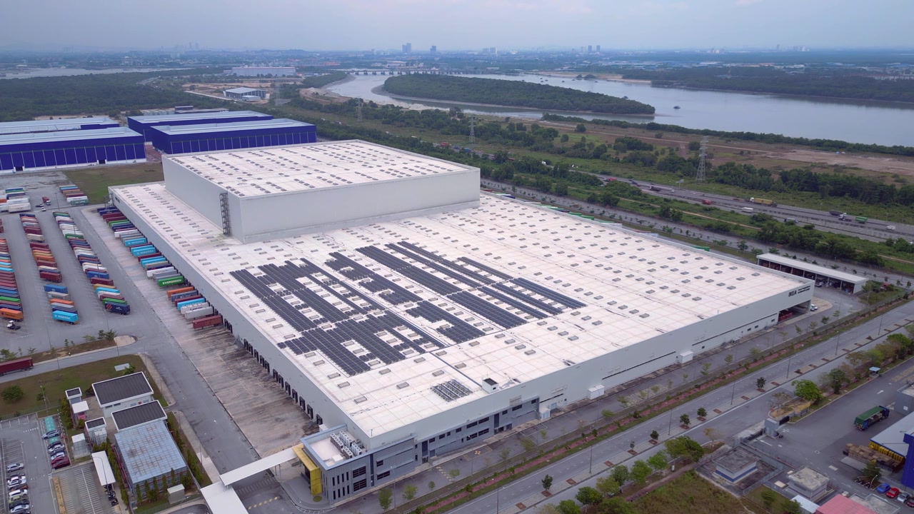 Vista aerea che mostra un moderno centro di distribuzione con camion e pannelli solari sul tetto a Port Klang, Malesia. Bella vista aerea, panorama statico ripreso da drone in hovering.