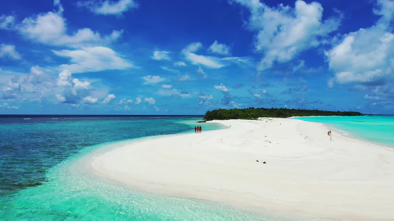 열대 바다의 모래톱을 따라 걷는 어린 소녀들