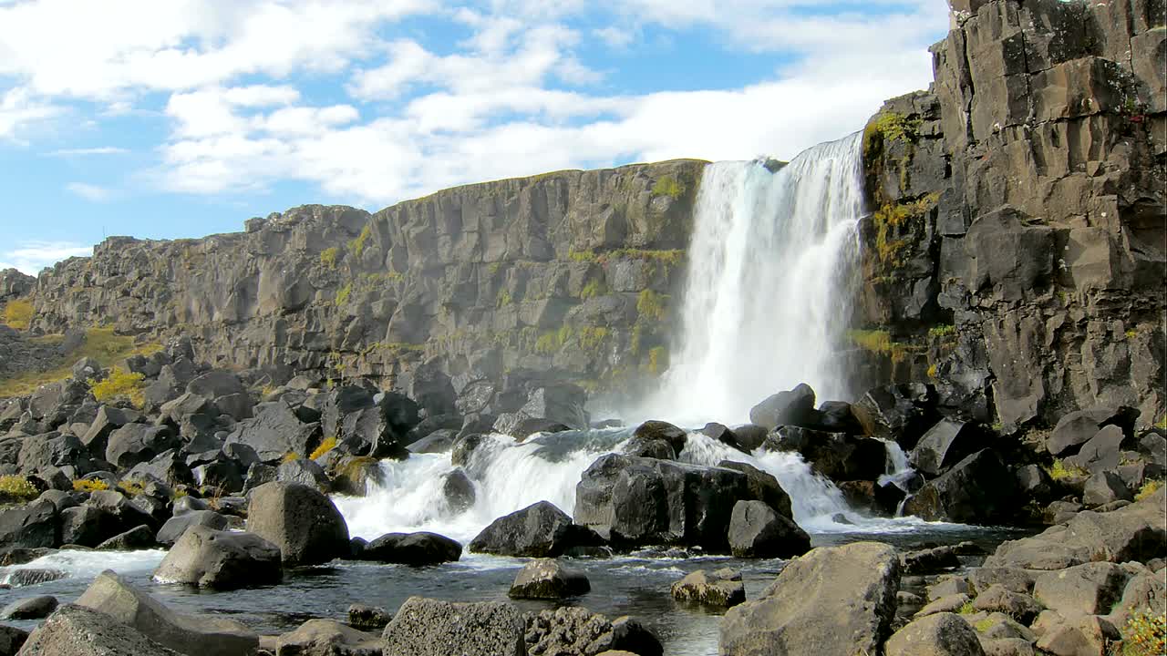 el relato de hadas de la pintoresca cascada, las nubes se mueven a la distancia, el sol suave está brillando