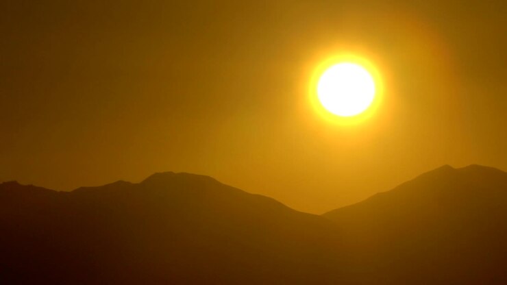 Rising Sun over the sea and desert mountains