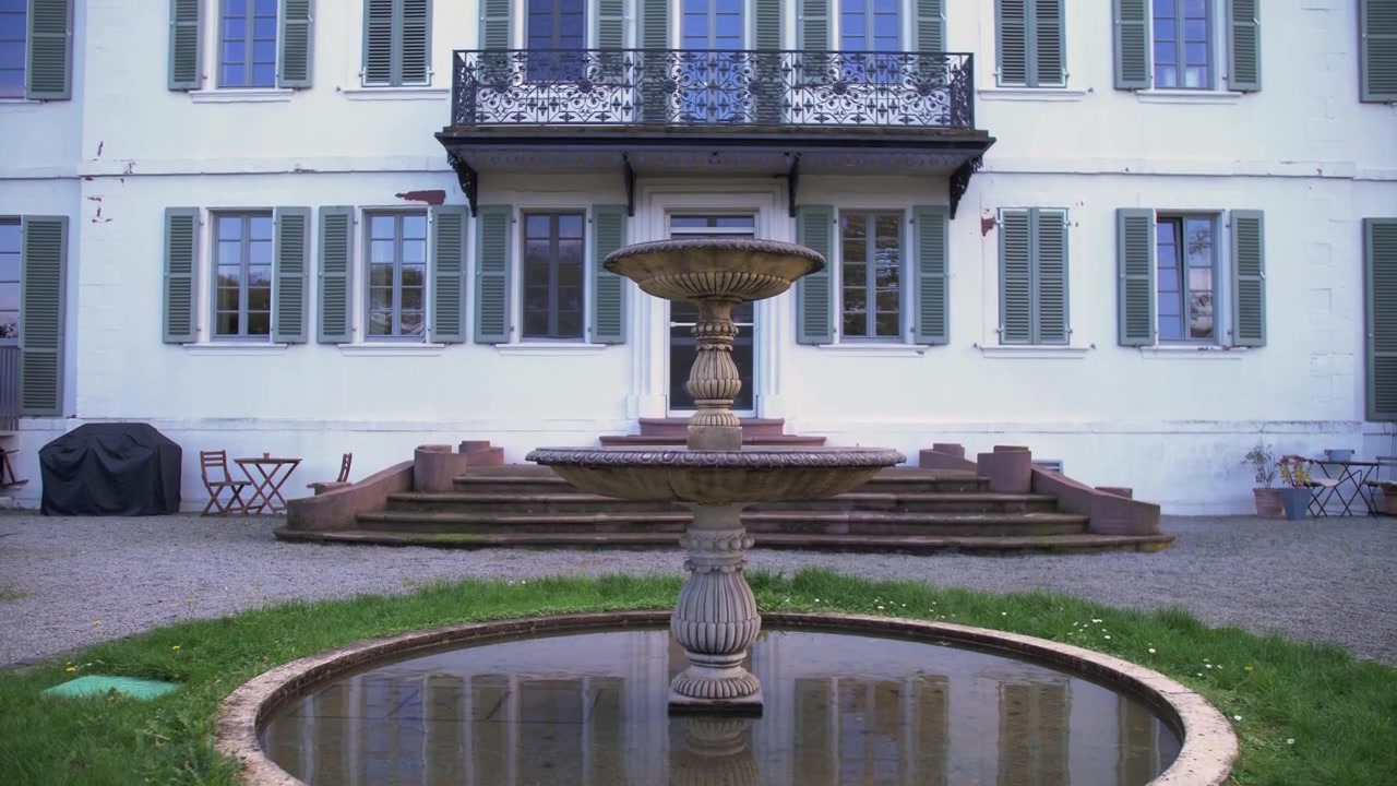 Vecchia fontana davanti a un palazzo bianco