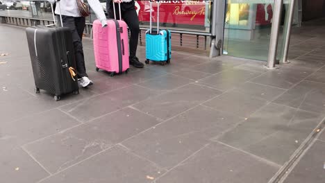 people moving luggage outside a building