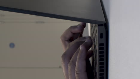 Person Mounting a Laptop on a Wall