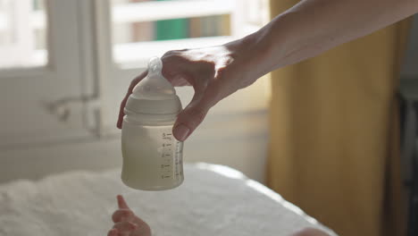 Mother-rinsing-milk-in-bottle-for-newborn-baby