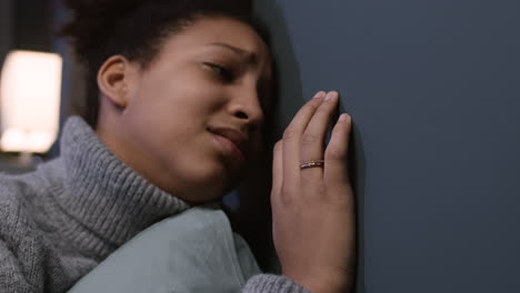 unhappy woman hugging a pillow on her bed