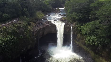 aerial push-out shot of the rainbow falls and green nature in hawaii