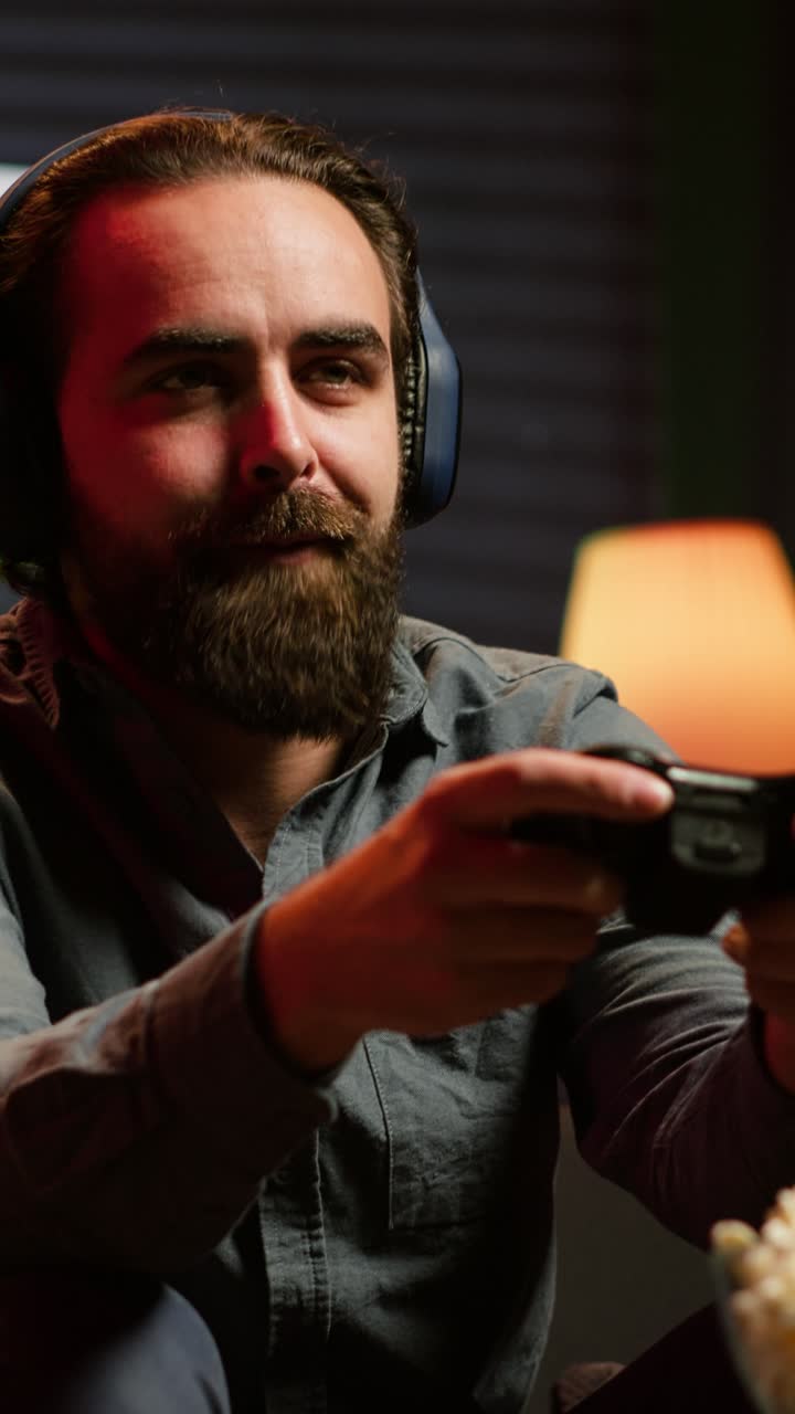 Vertical video Excited man playing videogames using controller, having fun