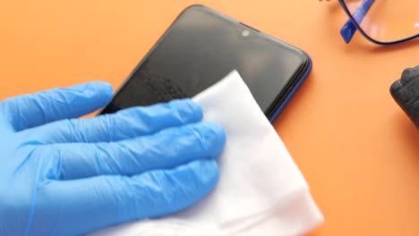 cleaning a smartphone with gloves