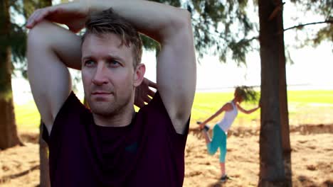 man performing stretching exercise in olive farm