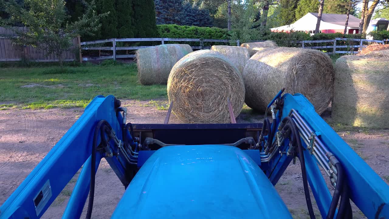 트랙터는 이 좋은 날 동안 시골 농장 설정에서 을 들어 올립니다.