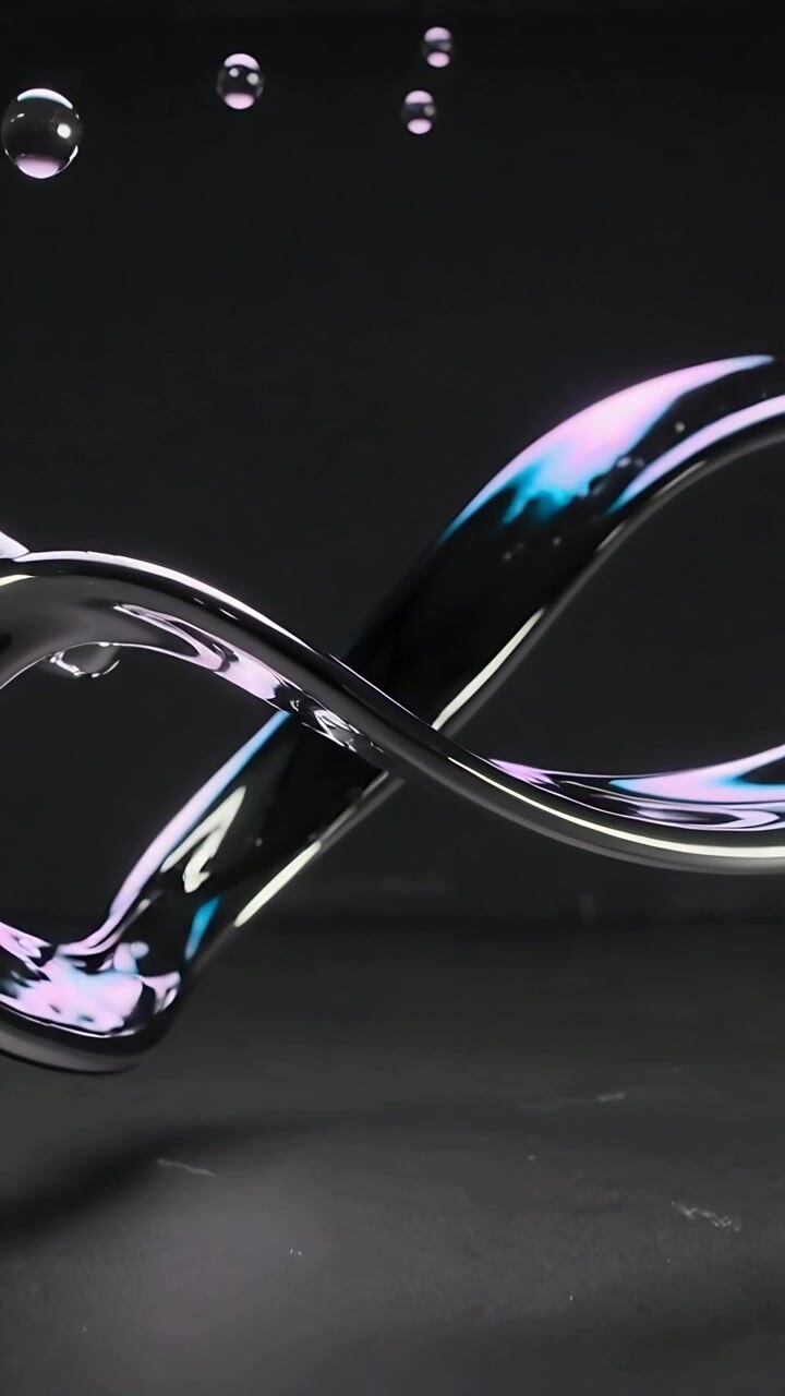 Vertical video: Twisting metallic ribbon looping in studio gravity pulling droplets lights shifting