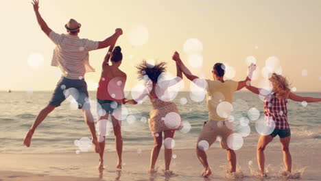 multi-ethnic friends jump hand-in-hand by the sea at sunset with bubble animation.