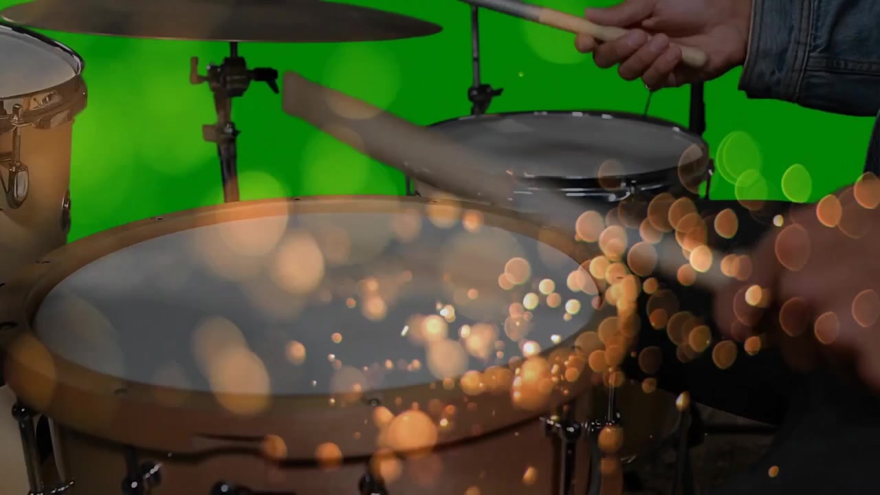 Batterista che posiziona le bacchette sul tom, battendo i ritmi, creando un bokeh dorato su un green screen per la musica.