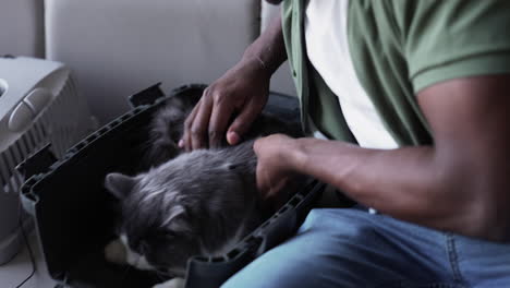 man taking cat out of the carrier