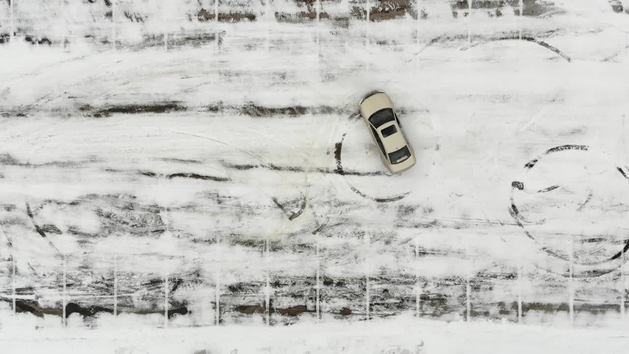 White Car attempting to do doughnuts in snowy parking lot