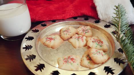 plate of christmas cookies and milk with a santa hat in 4k