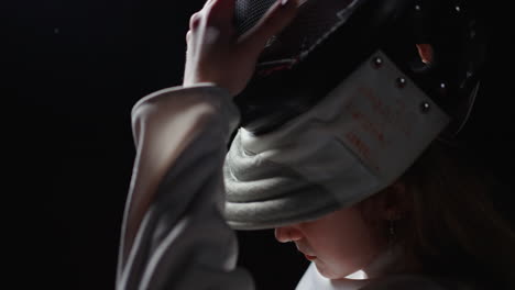 woman in fencing mask preparing for a match