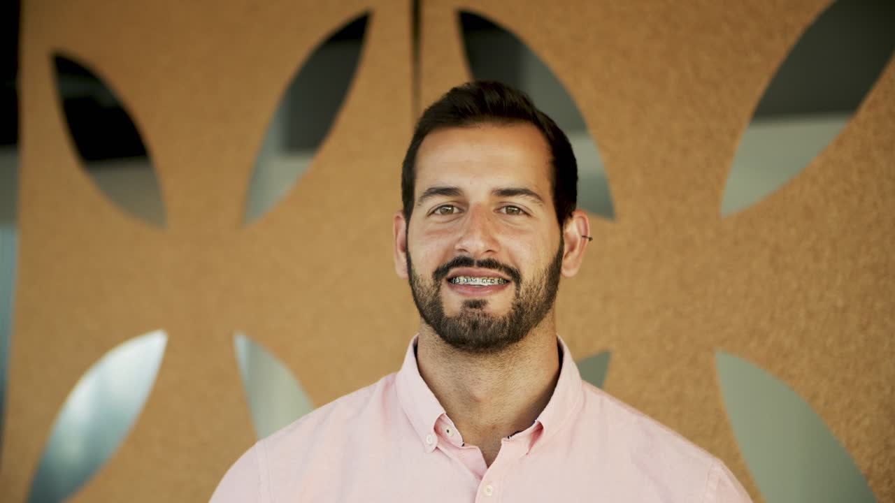 hombre joven con aparatos ortopédicos mirando a la cámara