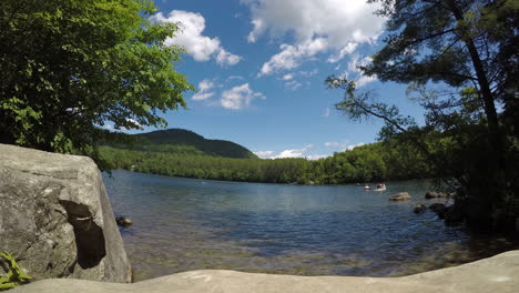 Hermoso-Lago-Espejo-En-El-Estado-De-Maine,-Imágenes-Panorámicas-De-Lapso-De-Tiempo-En-Primavera-Con-Nubes-Que-Se-Mueven-Rápidamente-Contra-Un-Cielo-Azul-Claro