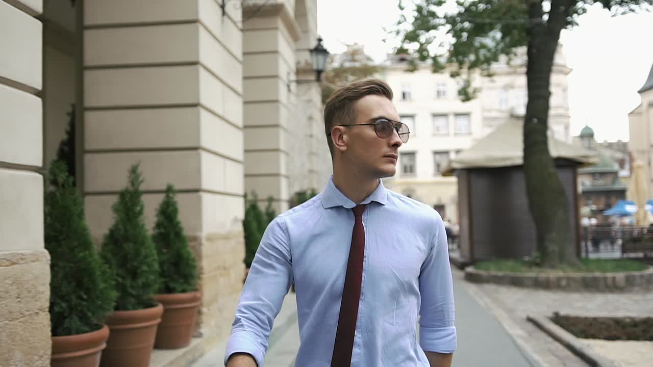 Man in tie and sunglasses on city street
