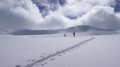 Low-angle-shot-of-backcountry-skiers-ascending-skin-track