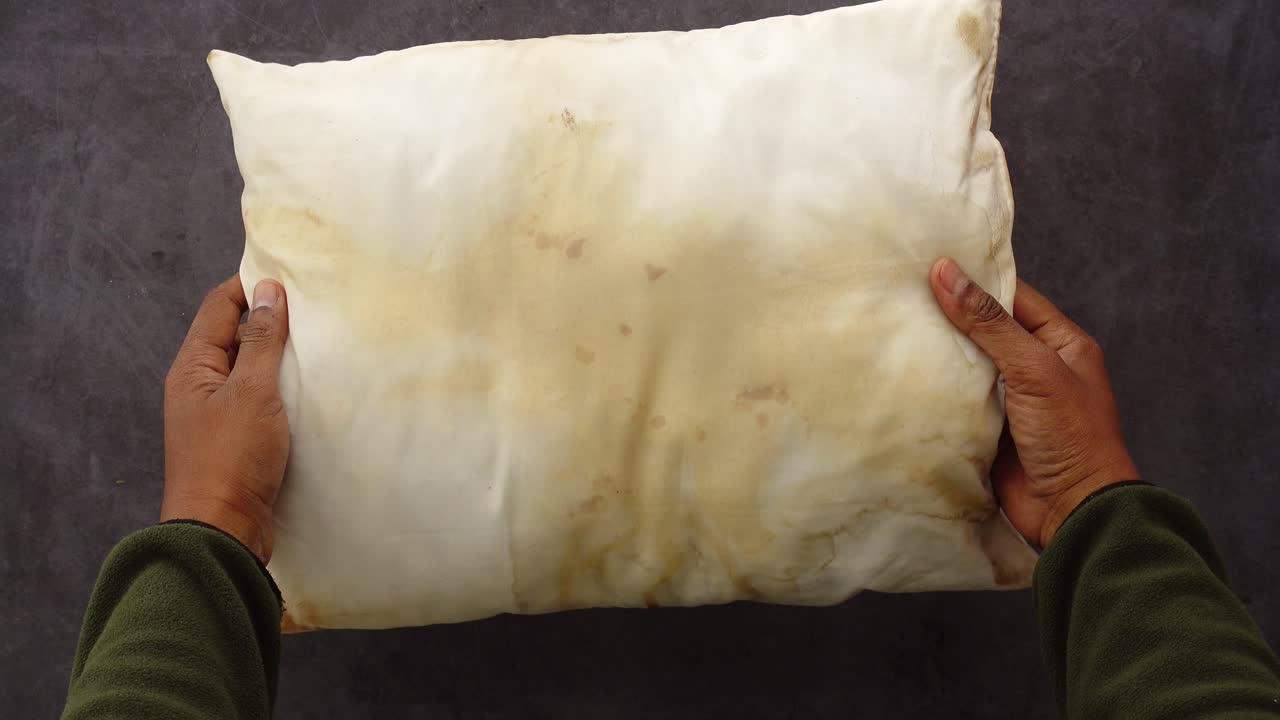 Dirty Pillow Held in Hands