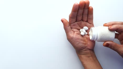 hand pouring pills from container