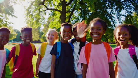 happy diverse children with backpacks in a sunny park