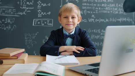 young student studying at a desk with a laptop in a classroom.