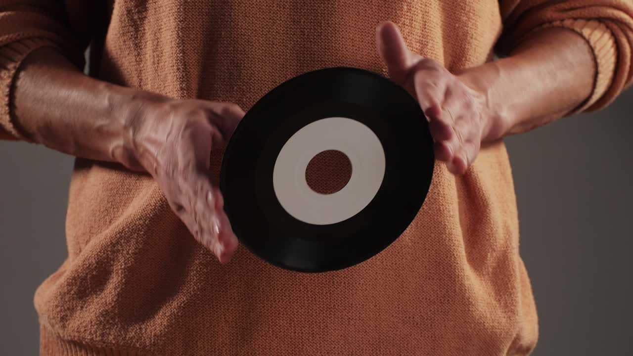 Retro Vinyl records in man hands close-up macro. Old disck for music. Retro vintage music player at home