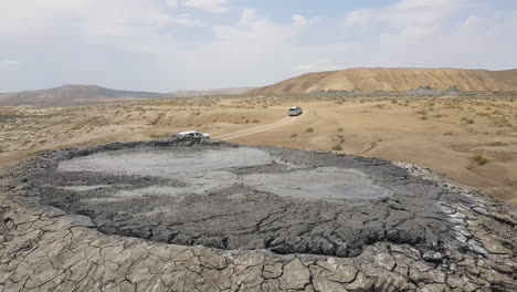 vehicles passing by under mud volcano in gobustan national park, azerbaijan