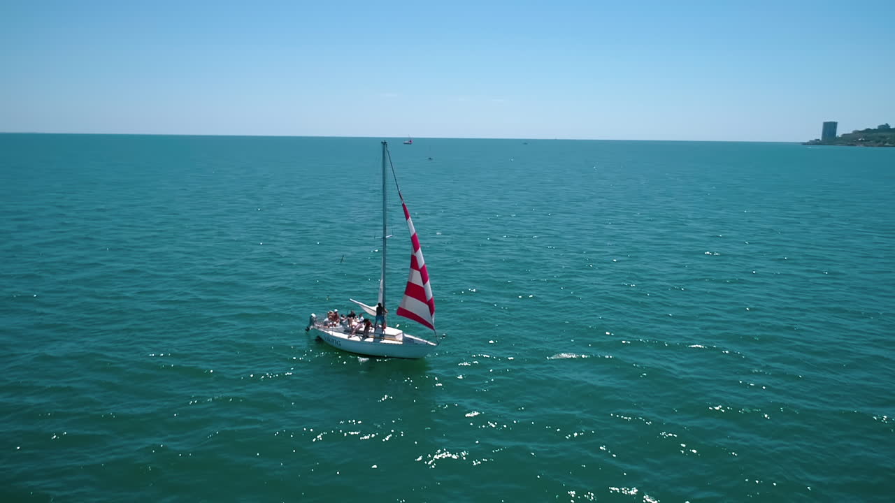 Sailboat cruise at serene seascape. Yacht sailing in open sea at windy day, aerial view