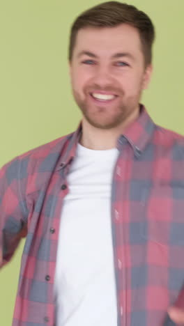 funny dance of a man in simple clothes on the background in the studio happy european man dancing funny dance of a man in simple clothes on the background in the studio happy european man dancing smiling at the camera