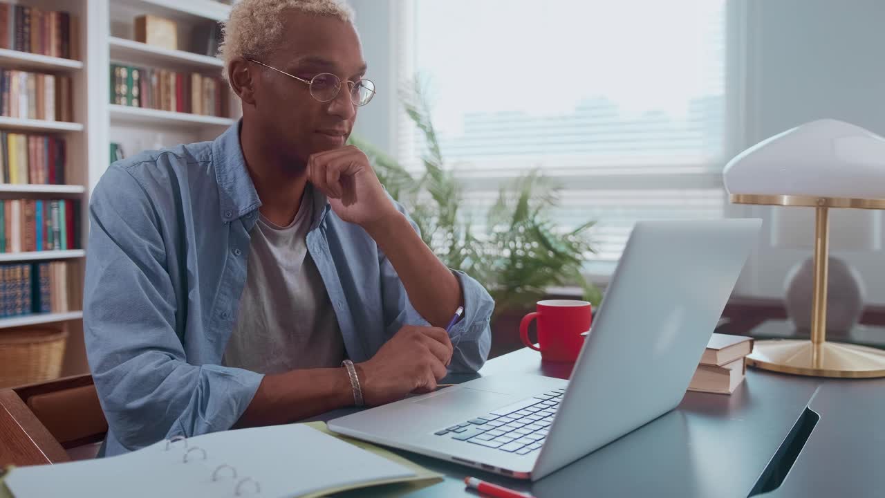 Portrait of attentive businessman with glasses sitting at office desk at work