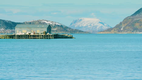 Long-lens-shot-of-a-boathouse-or-industrial-building-near-Tromvik,-Norway