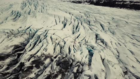 Glacier-tongue-in-Iceland-filmed-by-drone-with-different-cinematic-movements,-showing-a-cloudy,-dramatic-concept-in-wintery-conditions