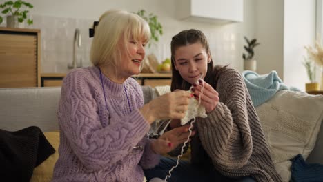 grandmother and granddaughter knitting together