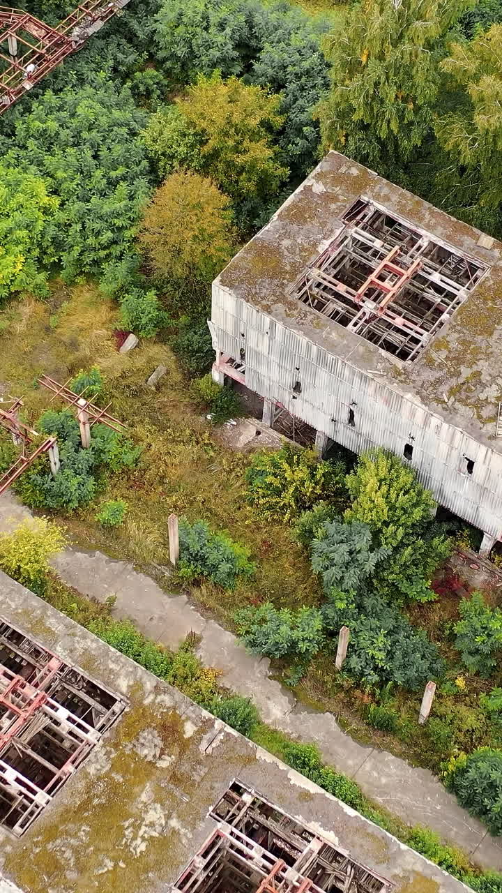 Aerial view of old abandoned factory. Empty destroyed factory buildings on the background. Vertical video