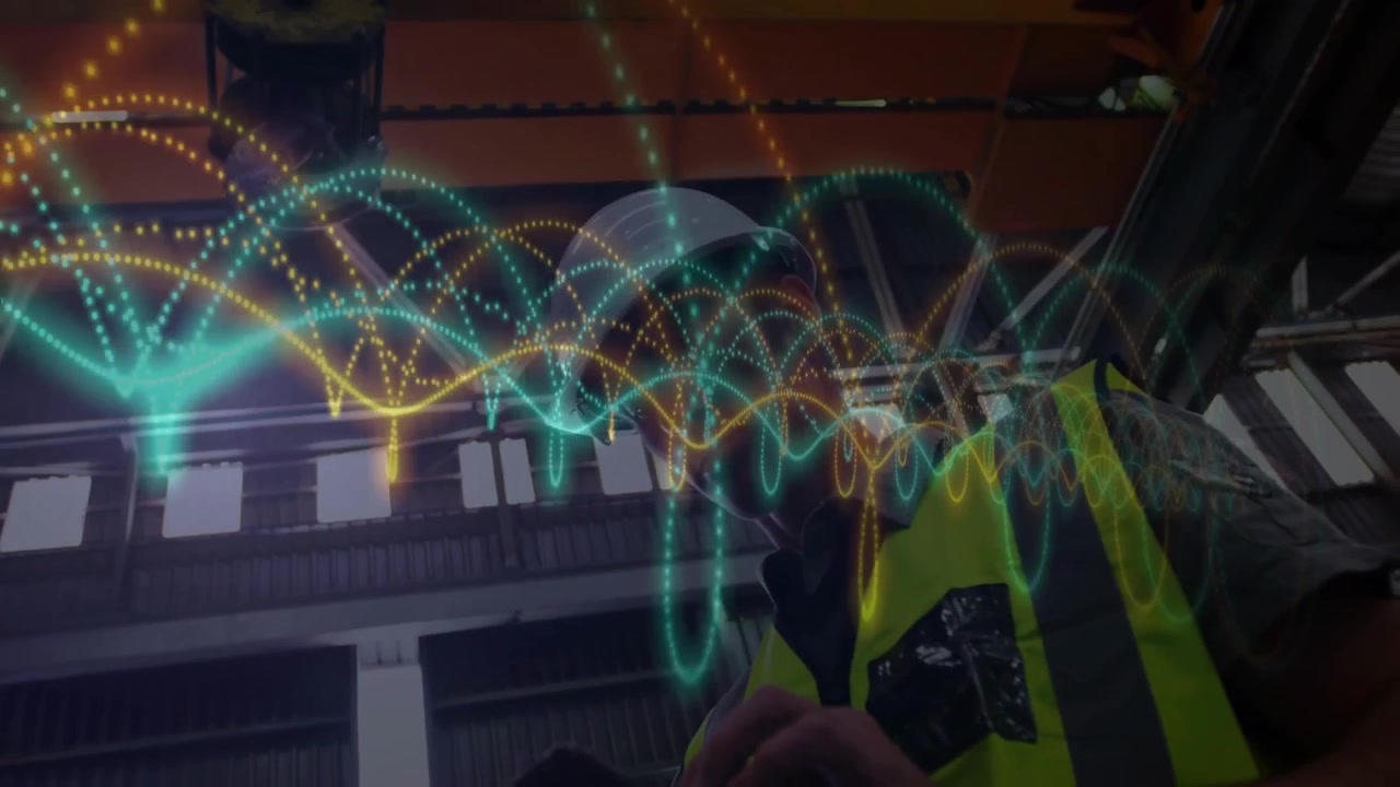 Male technician entering factory, scrolling handheld device, aligning floating arcs into data graph