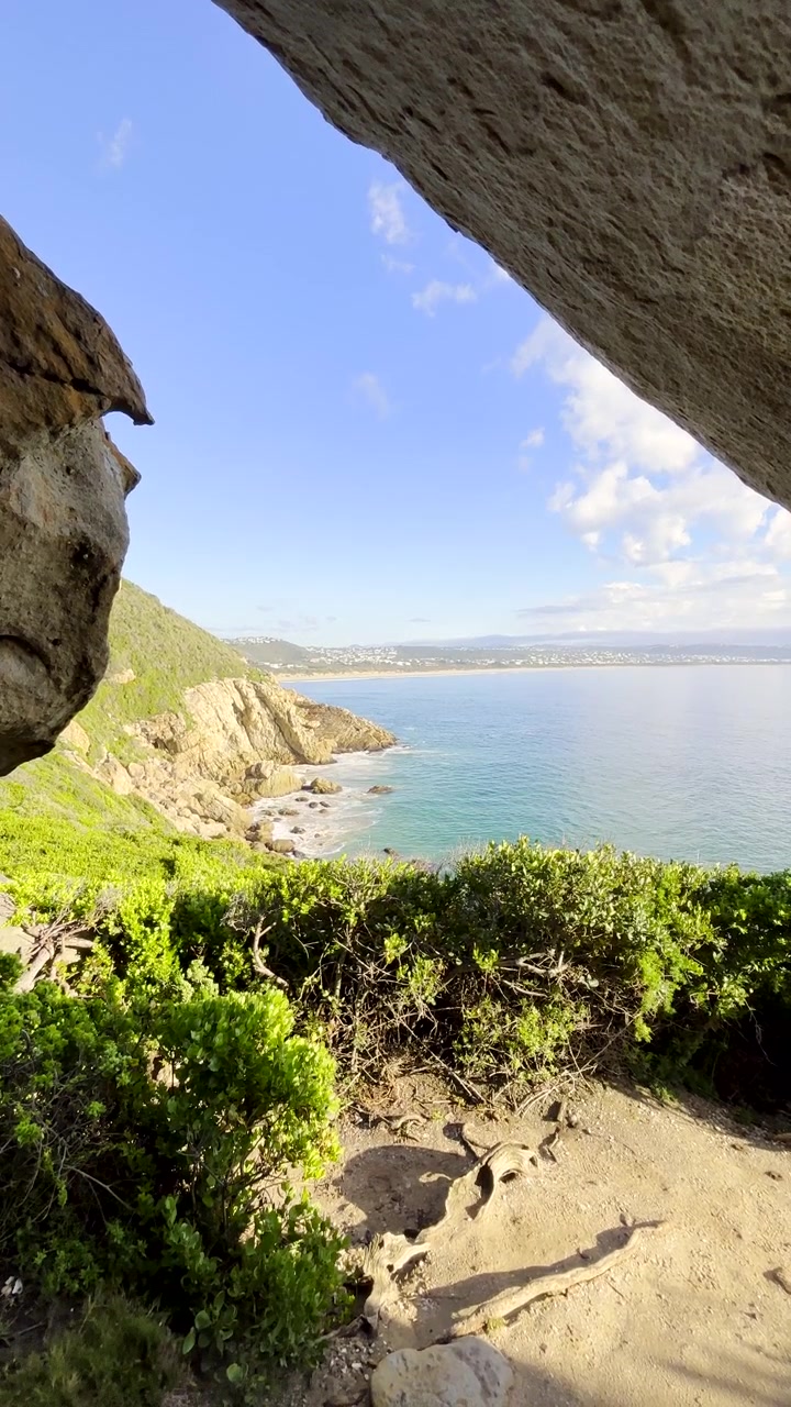 Grotzicht vanaf het Robberg rondwandelpad bij zonsopgang in Plett. Verticaal.