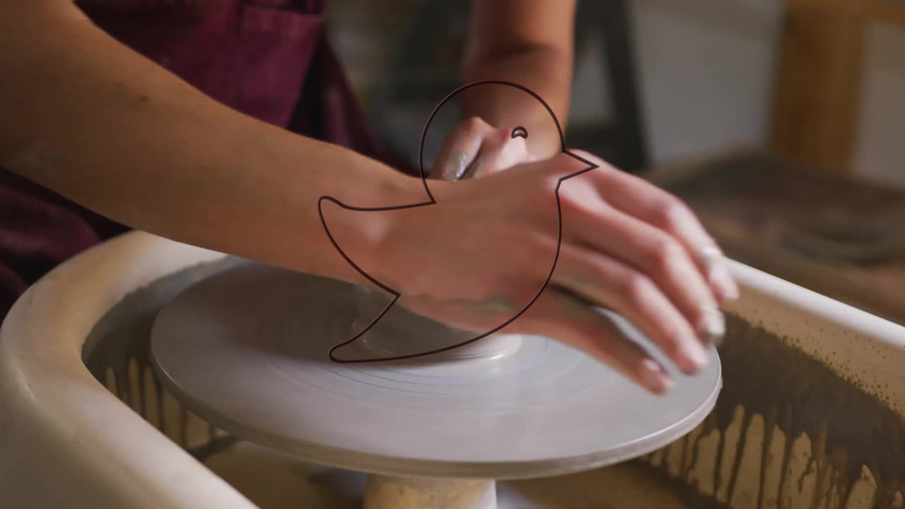Shaping clay on pottery wheel, person creating animation with red bird outline