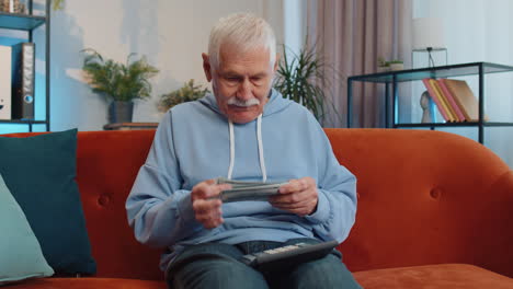 rich happy man counting money cash and use calculator, calculate domestic income earnings at home