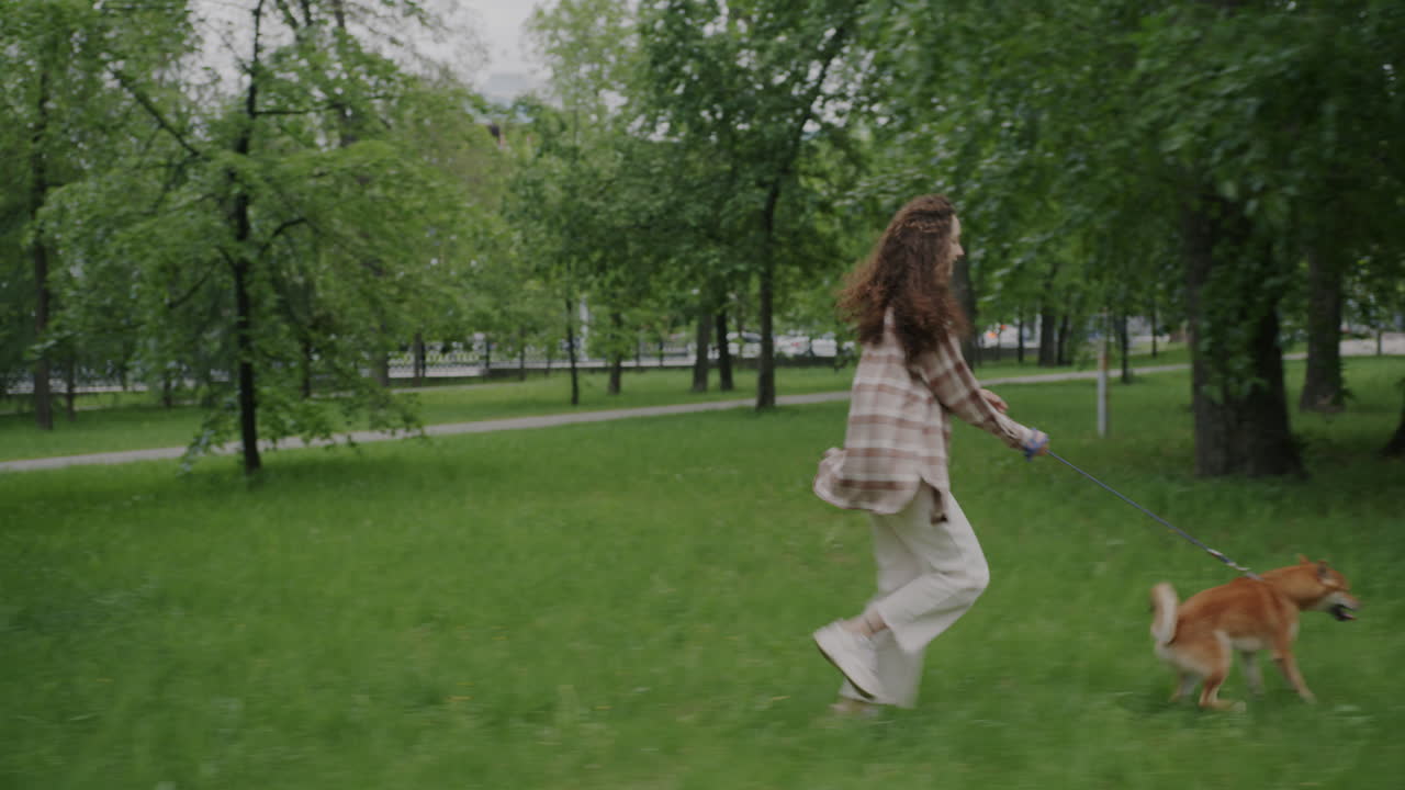 женщина гуляет с собакой в парке