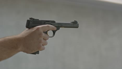 tirador apuntando una pistola y disparando de manera segura varios disparos en un campo de tiro