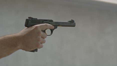 shooter aiming pistol and securely firing multiple shots on a firing range