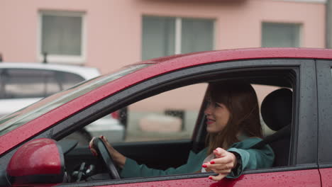 smiling woman drives car enjoying trip in rainy weather