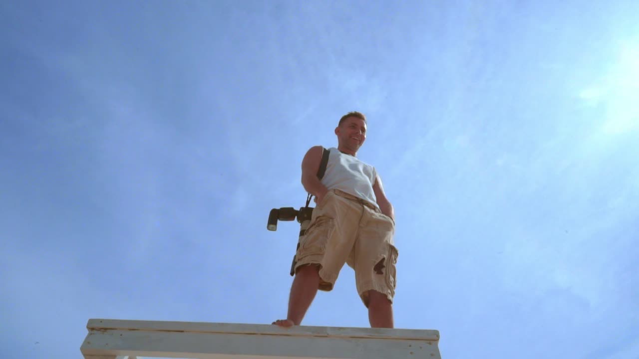 전문 사진작가 가 높은 곳 에서 촬영 한 후 휴식 하고 있다