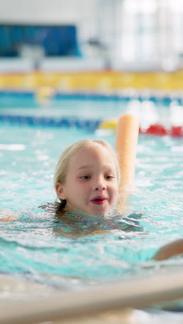 young girl learning to swim in a pool